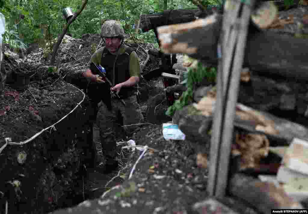 Український військовослужбовець йде вздовж лінії фронту під Авдіївкою. Київ просить країни Заходу надати важку артилерію, зокрема гаубиці та ракетні установки й снаряди до них, щоб можна було досягнути перелому у війні і захистити населені пункти України