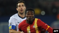 ABŞ-ın müdafiəçisi Carlos Bocanegra (ağ geyimdə)Qananın hücumçusu Asamoah Gyan ilə top uğrunda mübarizədə