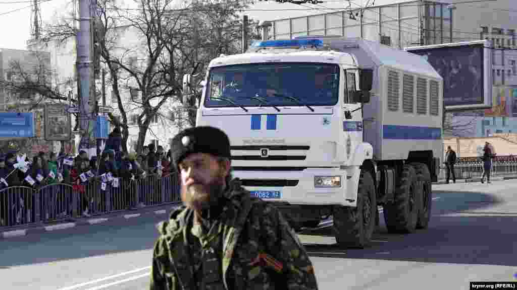 В Крыму начали праздновать вторую годовщину аннексии полуострова. Торжественное шествие, огражденное заборами, сопровождает автозак, 16 марта 2016 года