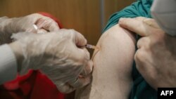 Serbia - A man receives a Pfizer-BioNTech Covid-19 vaccine at a clinic in Belgrade on January 13, 2021.