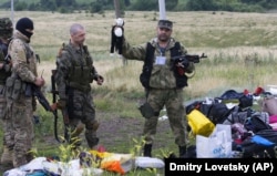 Бойовик російських гібридних сил тримає іграшку, виявлену на місці падіння уламків «Боїнга», збитого російською установкою «Бук», в результаті чого загинуло 298 людей, в тому числі 80 дітей. Донеччина, неподалік села Грабове, 19 липня 2014 року