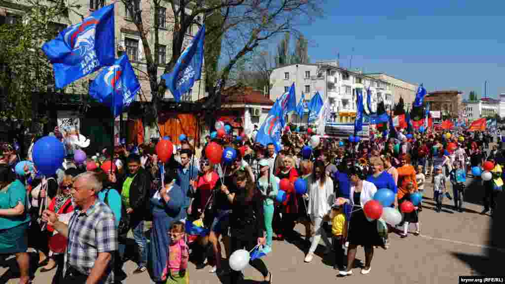 На первомайскую демонстрацию многие керчане взяли с собой детей. Люди несут в руках флаги, цветы, воздушные шары.&nbsp;