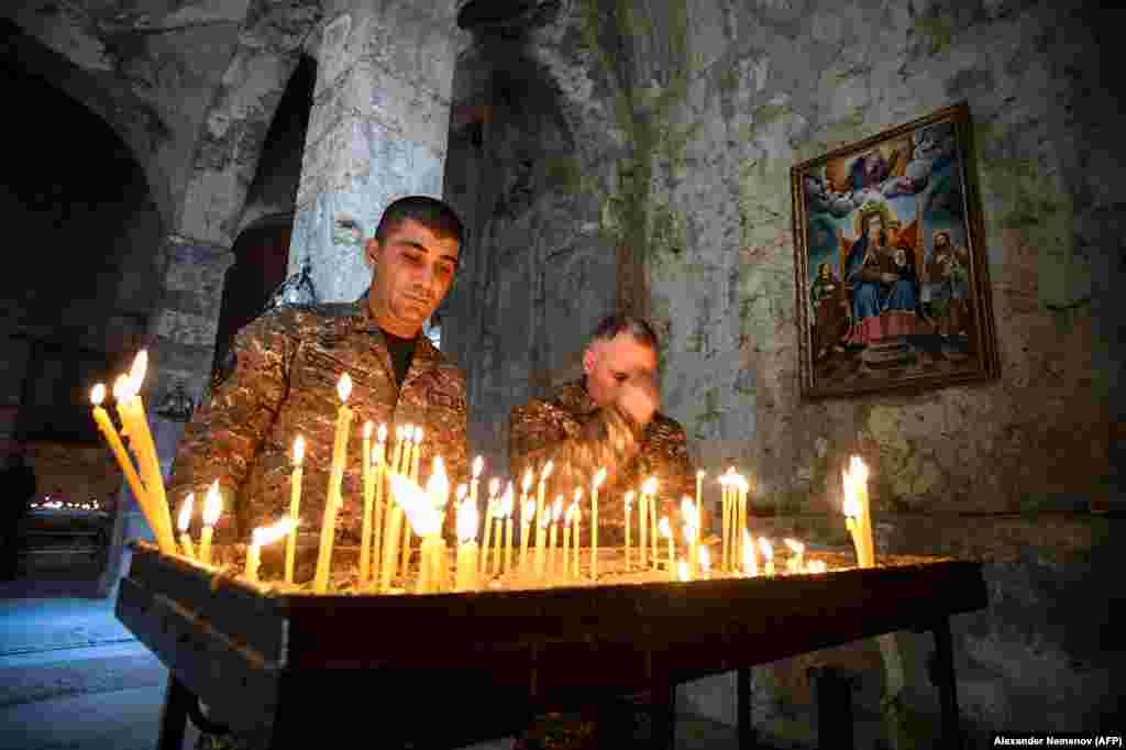 Армянские солдаты зажигают свечи в монастыре, отдавая дань памяти погибшим